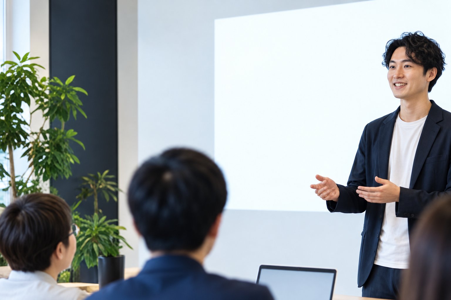スクリーンの前で話す講師と、聞いている参加者